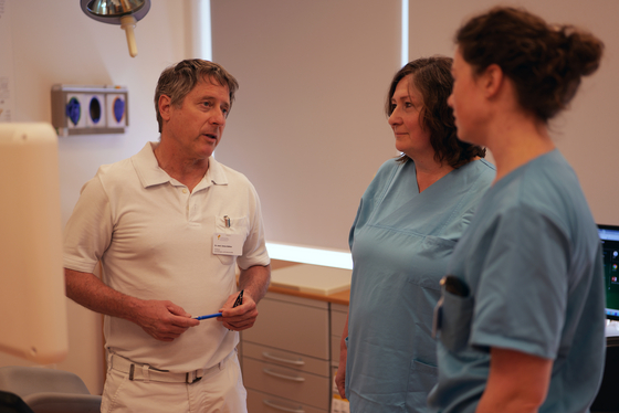Chefarzt der Frauenklinik Dr. Simon Bühler im Gespräch mit zwei Pflegefachkräften auf der Station im Evangelischen Amalie Sieveking Krankenhaus