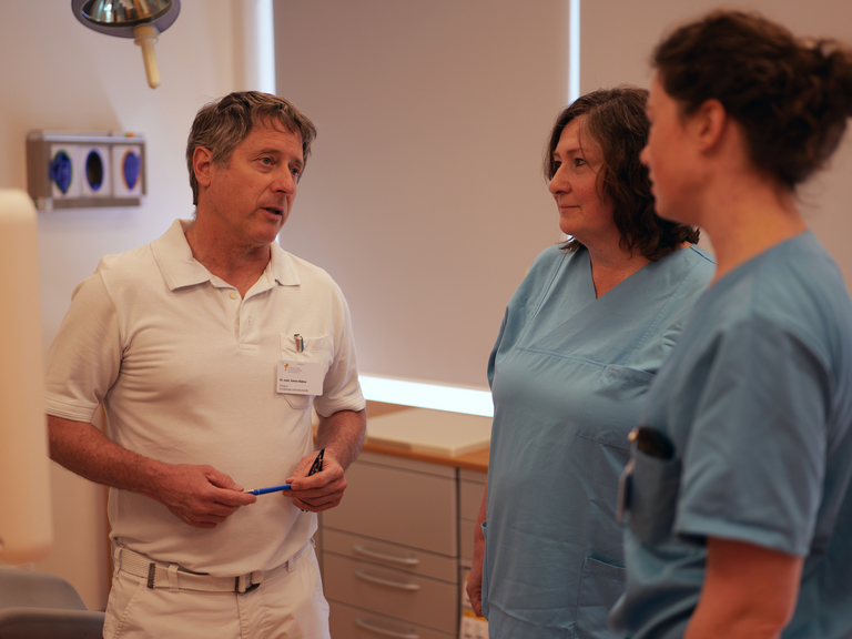 Chefarzt der Frauenklinik Dr. Simon Bühler im Gespräch mit zwei Pflegefachkräften auf der Station im Evangelischen Amalie Sieveking Krankenhaus