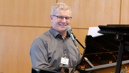 Pastor und Klinikseelsorger Roger Bahr sitzt am Klavier mit einem Mikrofon und trägt ein Stück vor bei der Weihnachtsfeier 2025 von Amalie Sieveking Krankenhaus, Residenz am Wiesenkamp, Feierabendhaus Volksdorf und Albertinen Kindertagesstätte Volksdorf auf dem Gesundheitscampus Volksdorf in Hamburg Pastor und Klinikseelsorger Roger Bahr sitzt am Klavier mit einem Mikrofon und trägt ein Stück vor bei der Weihnachtsfeier 2025 von Amalie Sieveking Krankenhaus, Residenz am Wiesenkamp, Feierabendhaus Volksdorf und Albertinen Kindertagesstätte Volksdorf auf dem Gesundheitscampus Volksdorf in Hamburg