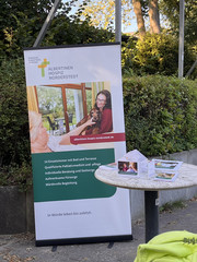 Infostand mit Tisch und Hospizbanner bei einem Fußballspiel des FC Eintracht Norderstedt vor dem Stadion bei der Aktion Pfandbecherspende für das Diakonie Hospiz Norderstedt