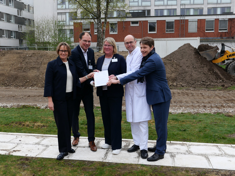 Hamburgs Sozialsenatorin Melanie Schlotzhauer, Amalie-Geschäftsführer Andreas Schneider, Pflegedirektorin Maike Sellentin, der Ärztliche Direktor Prof. Dr. Ernst von Dobschütz und der Konzerngeschäftsführer der Immanuel Albertinen Diakonie Dr. Thorsten Minuth (von links) halten symbolisch den Fördermittelbescheid über 53 Millionen Euro für den Neubau am Evangelischen Amalie Sieveking Krankenhaus in Hamburg-Volksdorf in die Kamera. Hamburgs Sozialsenatorin Melanie Schlotzhauer, Amalie-Geschäftsführer Andreas Schneider, Pflegedirektorin Maike Sellentin, der Ärztliche Direktor Prof. Dr. Ernst von Dobschütz und der Konzerngeschäftsführer der Immanuel Albertinen Diakonie Dr. Thorsten Minuth (von links) halten symbolisch den Fördermittelbescheid über 53 Millionen Euro für den Neubau am Evangelischen Amalie Sieveking Krankenhaus in Hamburg-Volksdorf in die Kamera.