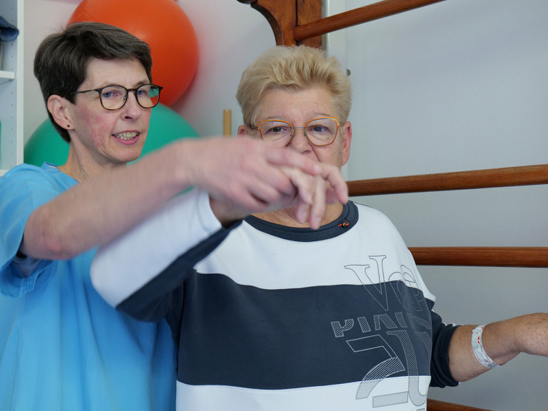 Ergotherapeutin begleitet Patientin bei Übung Ergotherapeutin begleitet Patientin bei Übung