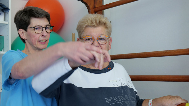 Ergotherapeutin begleitet Patientin bei Übung Ergotherapeutin begleitet Patientin bei Übung