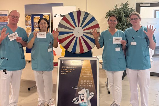 Mitarbeitende des Evangelischen Amalie Sieveking Krankenhauses präsentieren beim Aktionstag zur Händehygiene gewonnene Amazon-Gutscheine vor einem Glücksrad in der Eingangshalle. Mitarbeitende des Evangelischen Amalie Sieveking Krankenhauses präsentieren beim Aktionstag zur Händehygiene gewonnene Amazon-Gutscheine vor einem Glücksrad in der Eingangshalle.