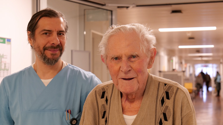Ein Pfleger gemeinsam mit einem Patienten auf dem Flur im Amalie Alterstraumazentrum