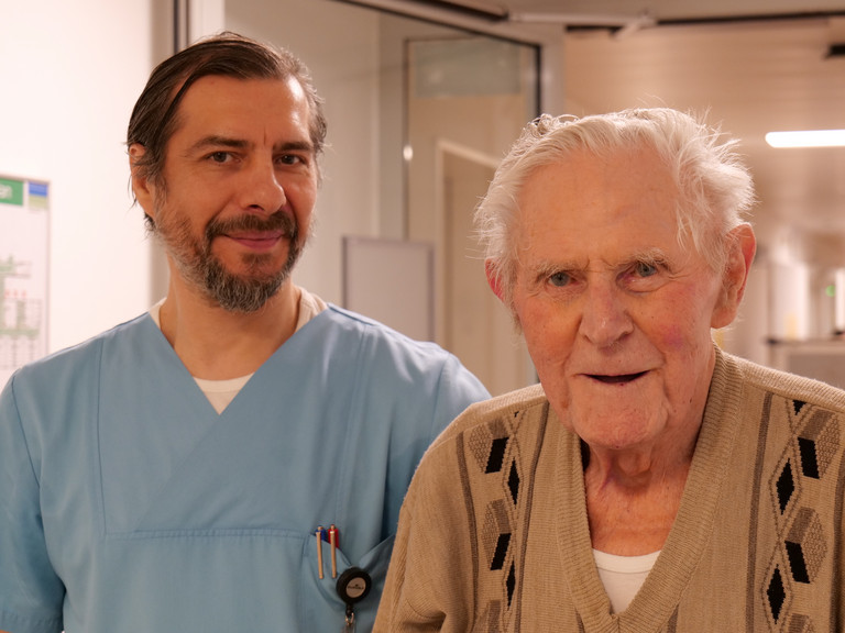 Ein Pfleger gemeinsam mit einem Patienten auf dem Flur im Amalie Alterstraumazentrum