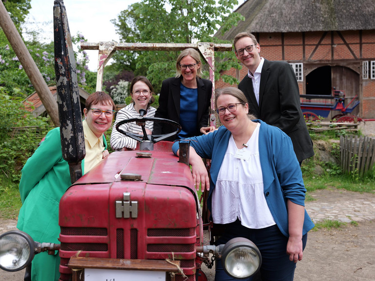 r. Saskia Otte mit Kolleginnen und Kollegen beim Einführungssymposium im Museumsdorf Volksdorf vor einem historischen Traktor.