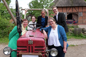 r. Saskia Otte mit Kolleginnen und Kollegen beim Einführungssymposium im Museumsdorf Volksdorf vor einem historischen Traktor.