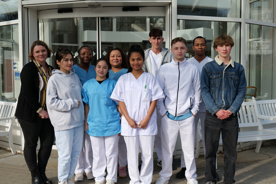 Gruppenfoto mit drei neuen Auszubildenden als Pflegefachfrau bzw. zum Pflegefachmann und drei Auszubildenden als Gesundheits- und Pflegeassistenz vor dem Eingang der Residenz am Wiesenkamp mit Petra Furmanski, hauptamtliche Praxisanleiterin und Ansprechpartnerin für die Auszubildenden.