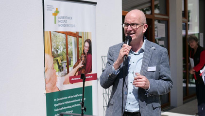 Geschäftsführer Walther Seiler spricht in ein Mikrofon zu Begrüßung am Tag der Begegnungen des Albertinen Hospiz Norderstedt