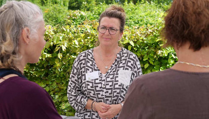Eine Mitarbeiterin unterhält sich an einem Infostand mit zwei Interessierten am Tag der Begegnungen des Albertinen Hospiz Norderstedt