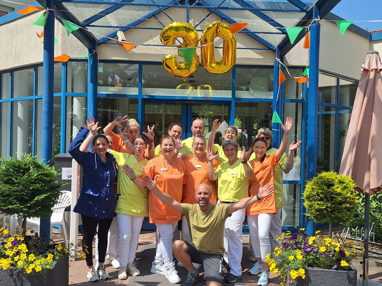 Gruppenbild des Teams vor dem Eingang mit einem 30 Ballon - Immanuel Haus Ecktannen in Waren