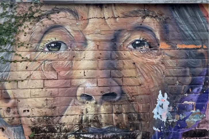 Wandgraffiti mit dem Gesicht einer älteren Frau in El Salvador zur Veranstaltung Altersmedizin neu gedacht – Perspektiven der  „Jungen Geriatrie - Fachsymposium Einführung Dr. med. Saskia Otte im Evangelischen Amalie Sieveking Krankenhaus in Hamburg