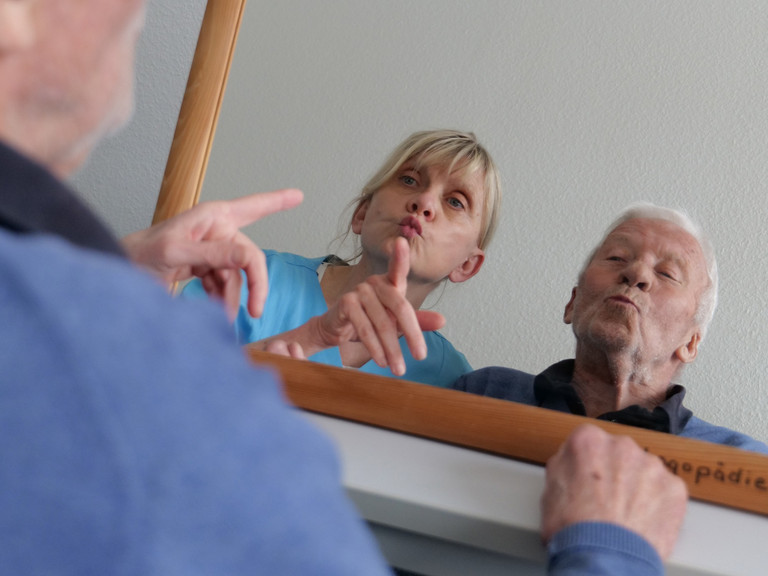 Therapeutin und Patient bei Sprachtherapie vor einem Spiegel - Evangeloisches Amalie Sieveking Krankenhaus Hamburg - Behandlung von Schluckstörungen und Schwierigkeiten beim Sprechen