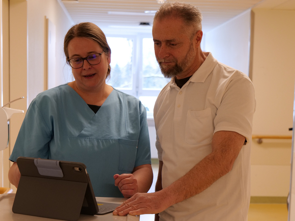 Dr. Saskia Otte, Chefärztin für Geriatrie und Physikalische Medizin, im gespräch mit einem Kollegen an einem Tablet
