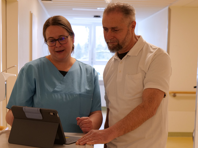 Dr. Saskia Otte, Chefärztin für Geriatrie und Physikalische Medizin, im gespräch mit einem Kollegen an einem Tablet
