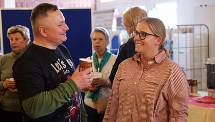 Ein Mitarbeiter mit einem Becher in der Hand unterhält sich fröhlich mit einer Kollegin bei der Weihnachtsfeier 2025 von Amalie Sieveking Krankenhaus, Residenz am Wiesenkamp, Feierabendhaus Volksdorf und Albertinen Kindertagesstätte Volksdorf auf dem Gesundheitscampus Volksdorf in Hamburg Ein Mitarbeiter mit einem Becher in der Hand unterhält sich fröhlich mit einer Kollegin bei der Weihnachtsfeier 2025 von Amalie Sieveking Krankenhaus, Residenz am Wiesenkamp, Feierabendhaus Volksdorf und Albertinen Kindertagesstätte Volksdorf auf dem Gesundheitscampus Volksdorf in Hamburg