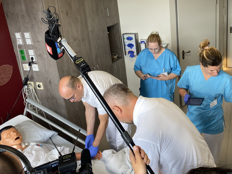 Der Ärztliche Direktor Prof. Dr. med. Ernst von Dobschütz und ein Pflegeteam stehen an einem Pflegebett mit einer Übungspuppe bei der Übung zur Patientensicherheit Room of Horrors mit TV-Begleitung im Amalie Sieveking Krankenhaus in Hamburg-Volksdorf