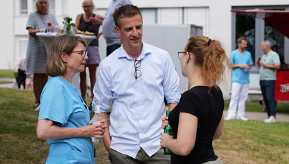 Priv.-Doz. Dr. med. Johannes Kluwe unterhält sich mit zwei Kolleginnen beim Sommerfest 2026 auf dem Gesundheitscampus Volksdorf des Evangelischen Amalie Sieveking Krankenhauses, der Residenz am Wiesenkamp, des Feierabendhauses Volksdorf und der Albertinen Kindertagesstätte Volksdorf.