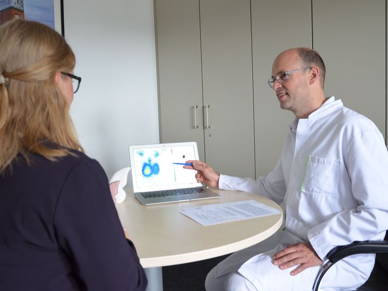Gesprächssituation zwischen Arzt und Patientin an einem Tisch, Zentrum für endokrine Chirurgie, Hamburg