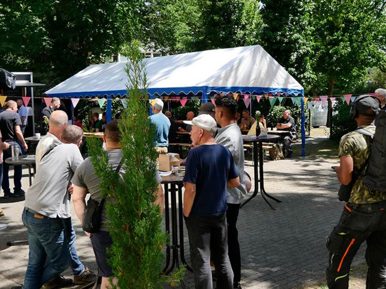 Menschen an Stehtischen im Hof