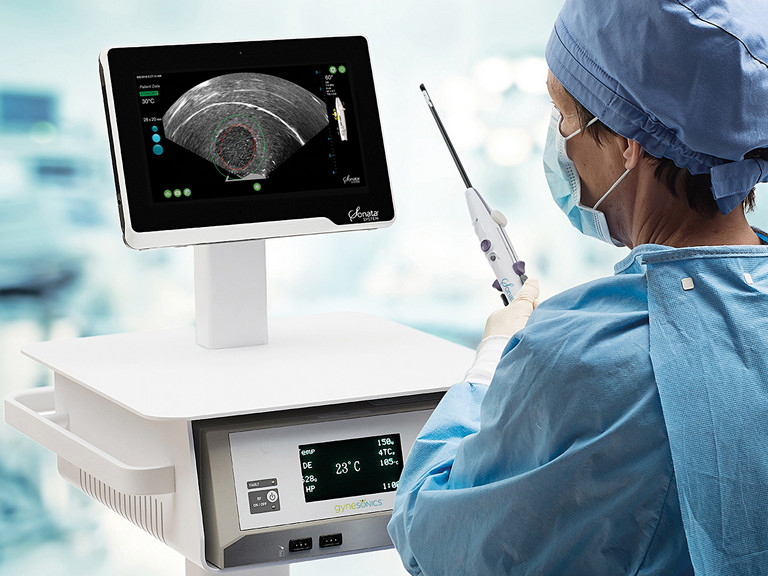 Eine ärztliche Person in OP Kleidung schaut auf einen Ultraschallbildschirm und hält das Sonata® System in der Hand