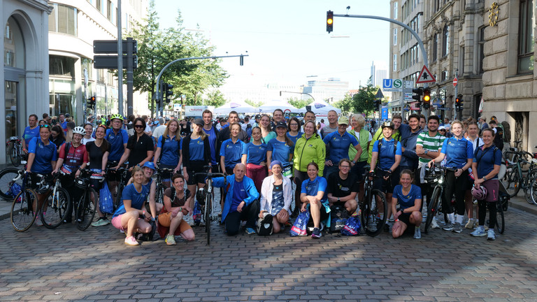 Eine Gruppe von Mitarbeiterinnen und Mitarbeitern der Immanuel Albertinen Diakonie die beim Hamburger Triathlon gestartet sind, sie tragen bunte Trikots Eine Gruppe von Mitarbeiterinnen und Mitarbeitern der Immanuel Albertinen Diakonie die beim Hamburger Triathlon gestartet sind, sie tragen bunte Trikots