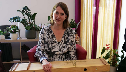 Eine Frau über einem Harfeninstrument blickt in die Kamera am Tag der Begegnungen des Albertinen Hospiz Norderstedt