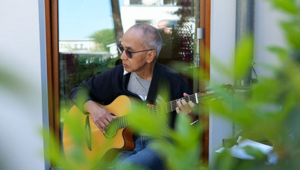 Ein Musiker musiziert sitzend mit einer Gitarre am Tag der Begegnungen des Albertinen Hospiz Norderstedt