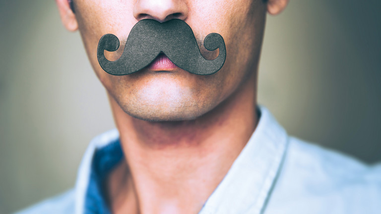 Mann mit großem schwarzen Papier-Schnurrbart als Symbol für die Movember-Aktion zur Männergesundheit des Albertinen Krankenhauses Hamburg und des HSVH.