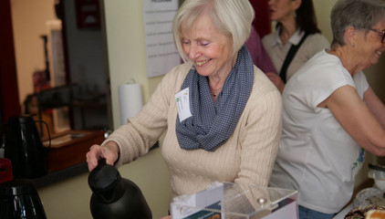 Eine Frau schenkt Kaffee an der Kaffeetafel aus am Tag der Begegnungen des Albertinen Hospiz Norderstedt