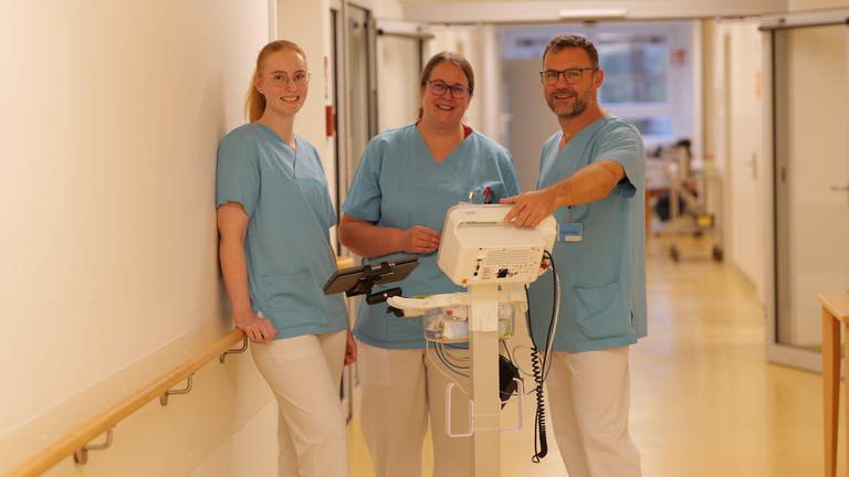 Drei Mitarbeiter in blauen Kasacks in der Geriatrie des Amalie Sieveking Krankenhauses in Hamburg